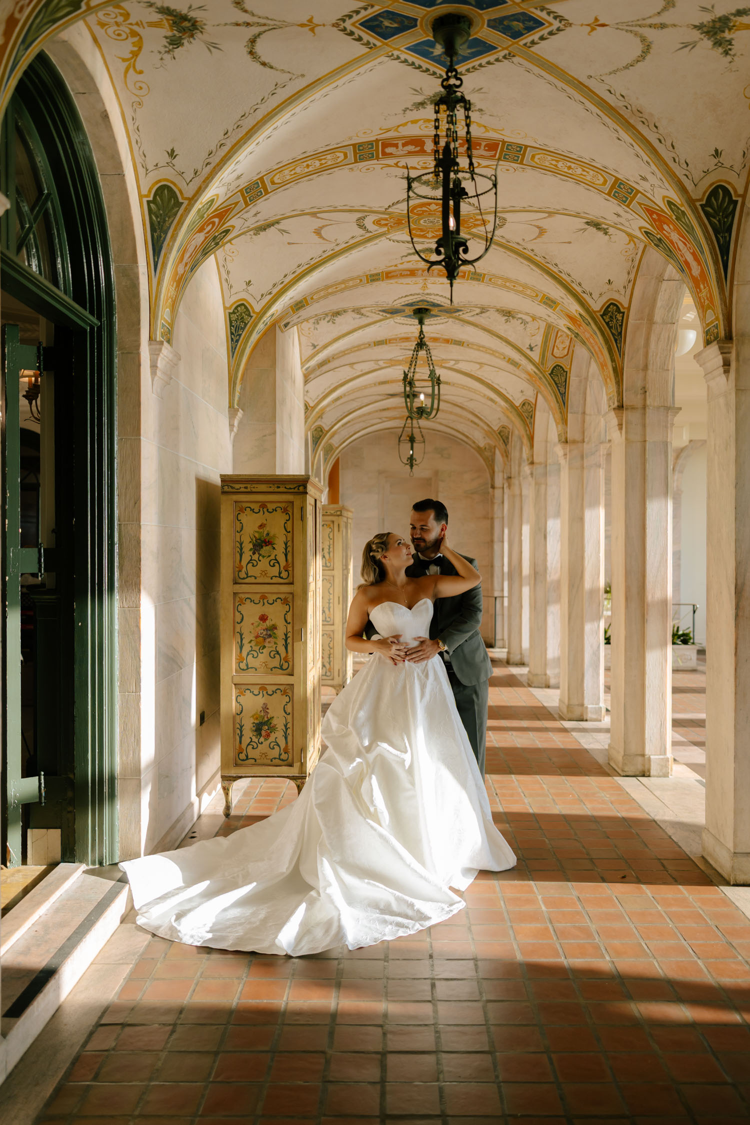 Editorial wedding portrait of a bride and groom under historic arch at New College Sarasota 
