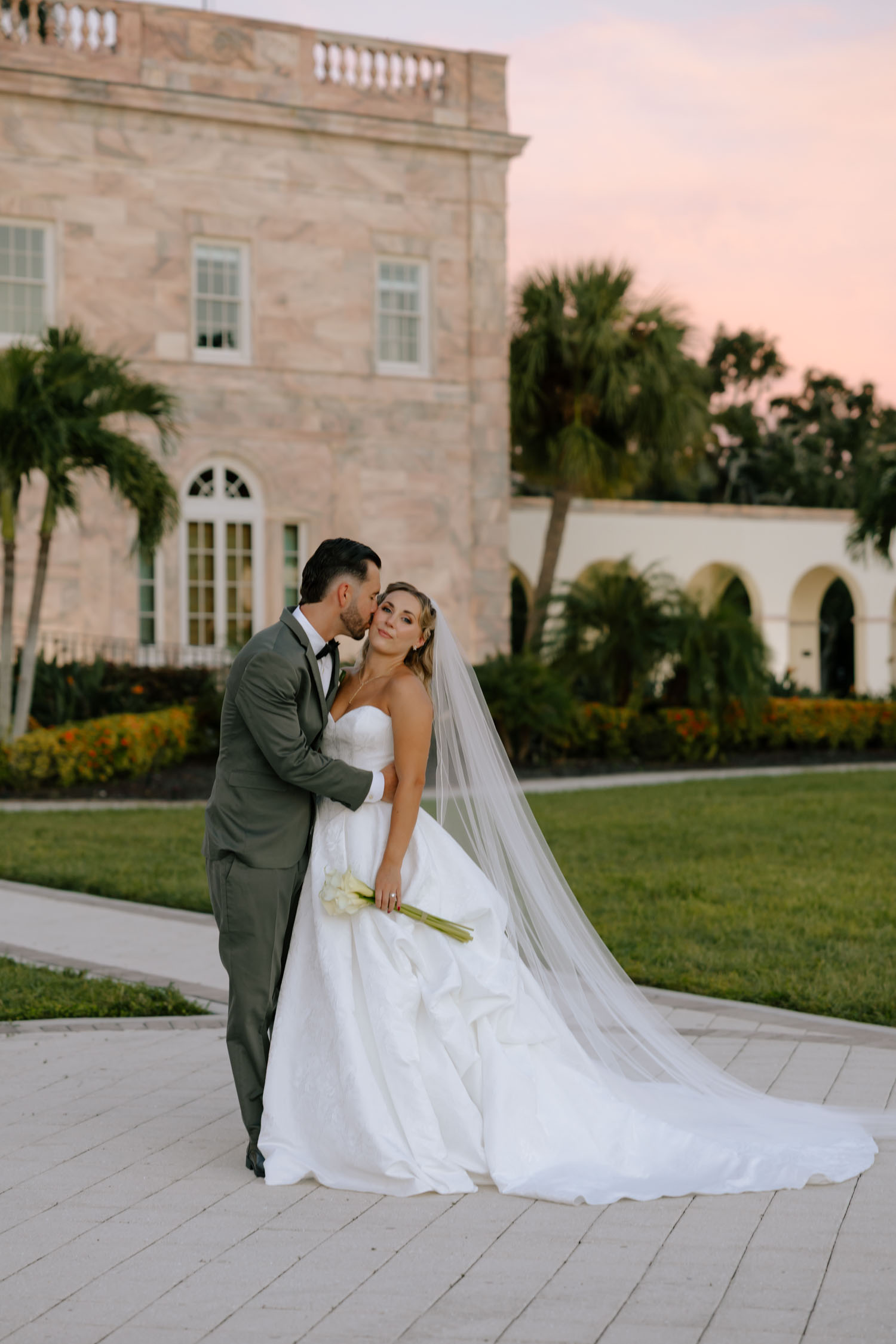 Bride and groom enjoying golden hour wedding portraits overlooking the water in Sarasota