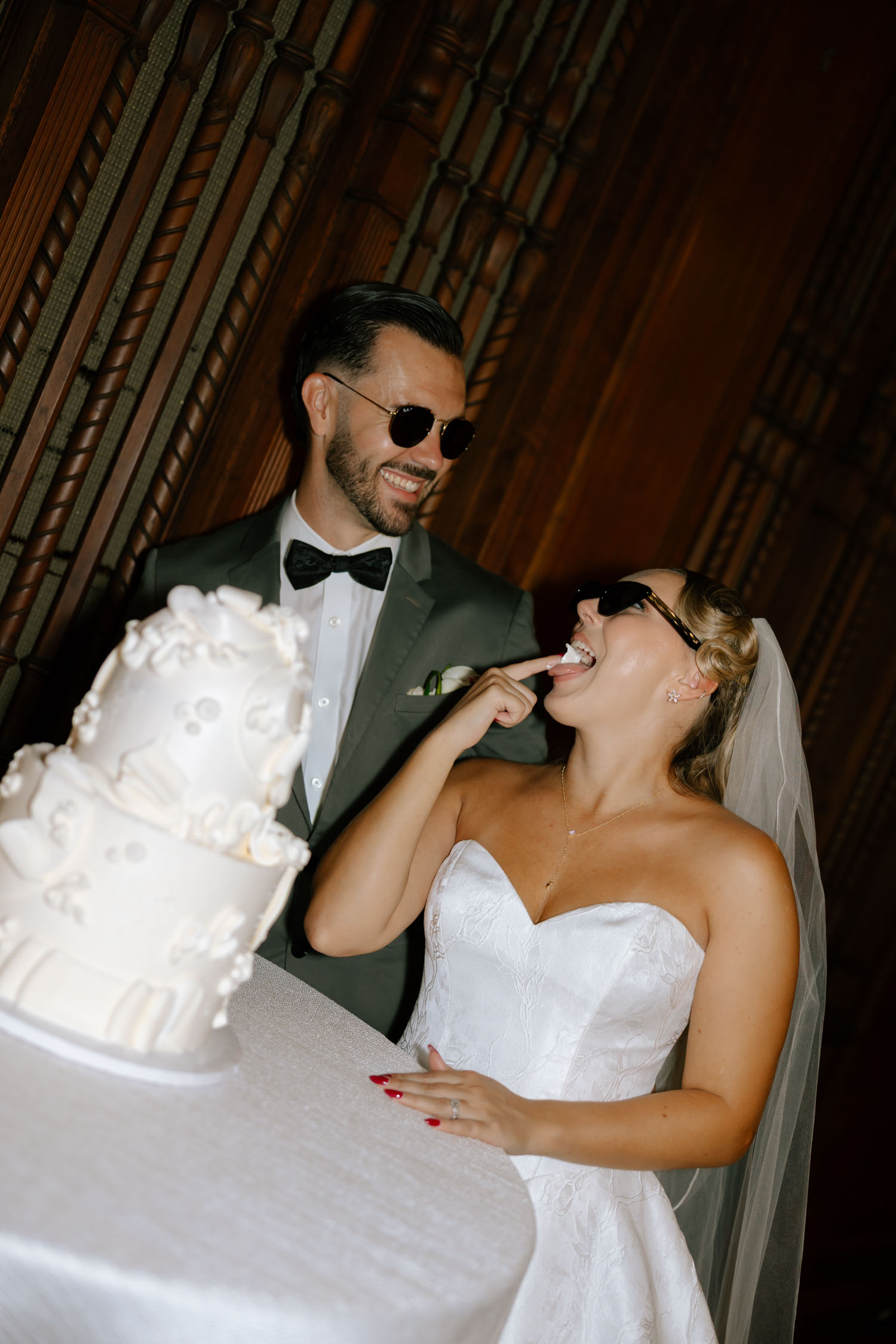Flash wedding portrait of a bride and groom eating their cake at New College Sarasota